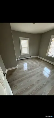 a view of empty room with wooden floor