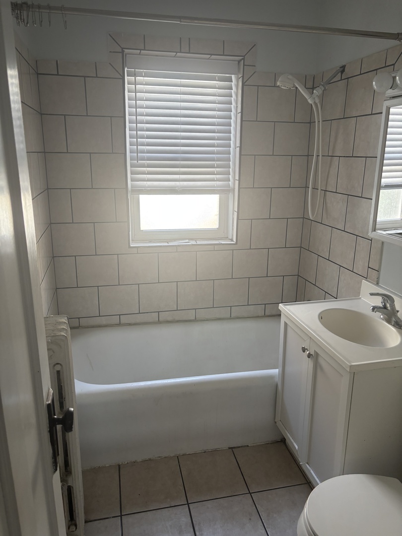 5440 North Campbell Avenue, Unit 3F Chicago, IL 60625 - Photo 4 of 7 a white bath tub sitting next to a white sink and a toilet