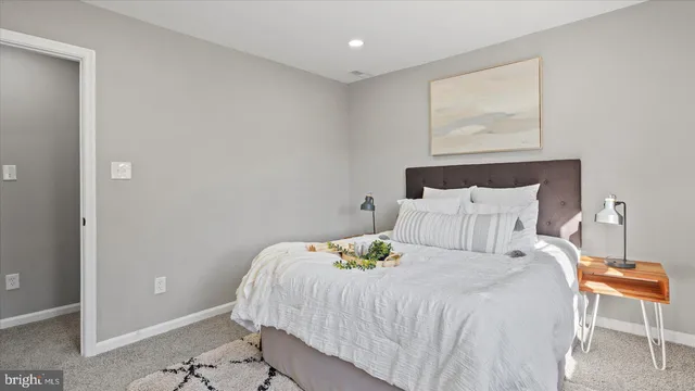 a bedroom with a bed and a painting on the wall