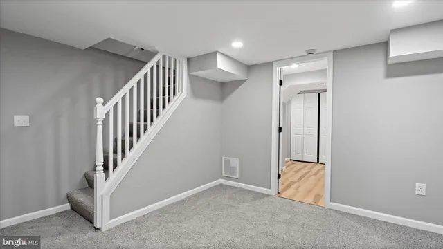 a view of a hallway with entryway and stairs