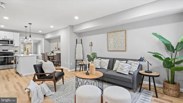 a living room with furniture kitchen and a potted plant