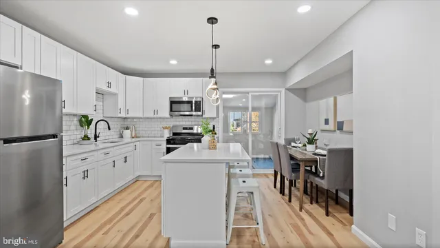 a kitchen with kitchen island white cabinets and refrigerator