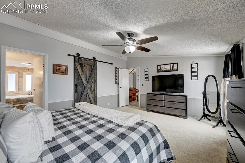 237 9th Street Penrose, CO 81240 - Photo 13 of 24 a bedroom with a large bed and a flat screen tv