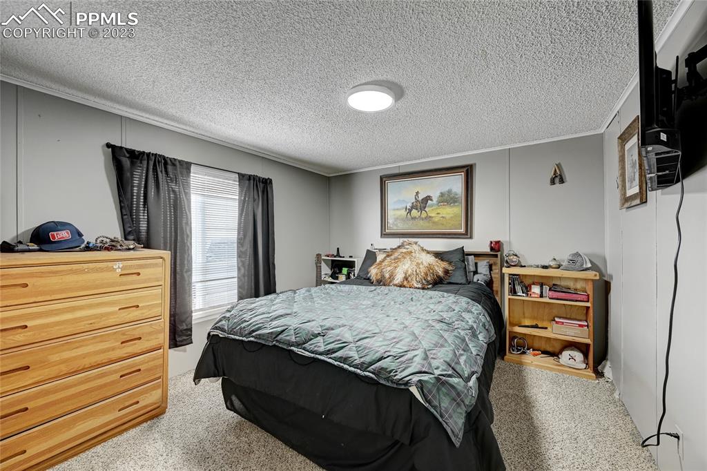237 9th Street Penrose, CO 81240 - Photo 18 of 24 a bedroom with a bed and a dresser