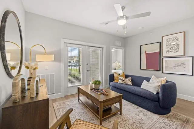 a living room with furniture a large window and a chandelier