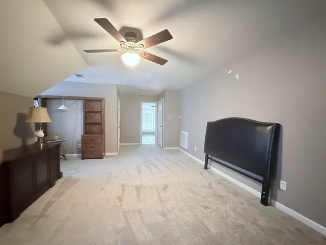 a living room with furniture and a ceiling fan
