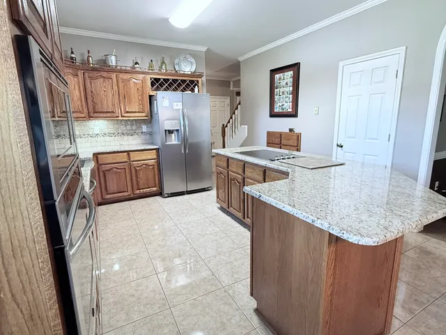 a kitchen with stainless steel appliances granite countertop a refrigerator stove and sink