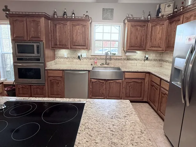 a kitchen with stainless steel appliances granite countertop a sink stove and refrigerator