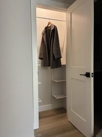 a view of walk in closet with clothes and shoes