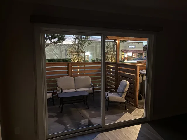 a dining room with furniture and a floor to ceiling window