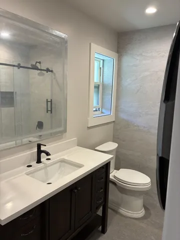 a bathroom with a sink toilet a mirror and shower