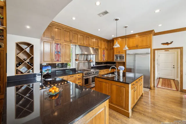 a kitchen with stainless steel appliances granite countertop a sink stove and refrigerator