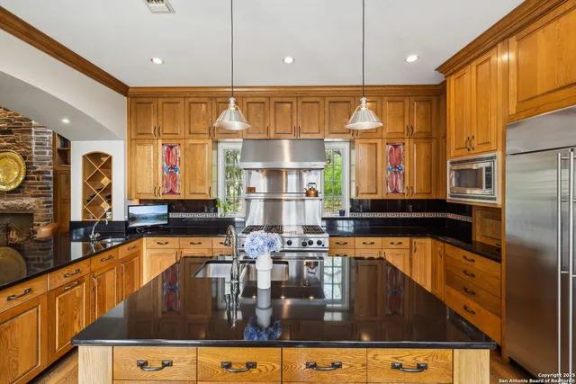 a kitchen with stainless steel appliances kitchen island granite countertop a sink and cabinets