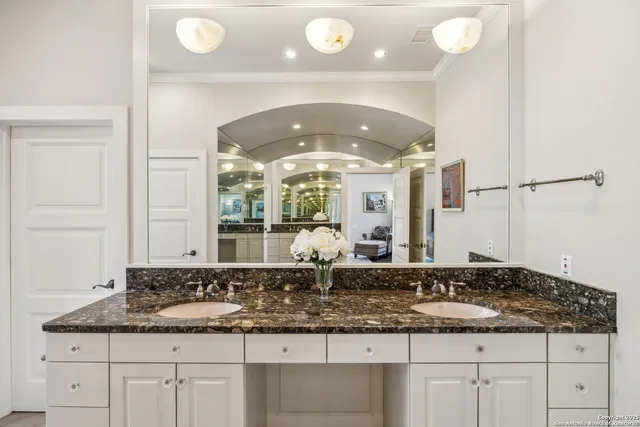 a bathroom with a granite countertop sink and a mirror