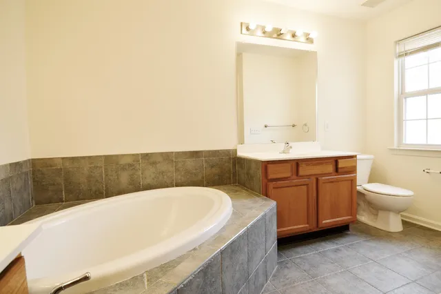 a bathroom with a granite countertop sink and a toilet