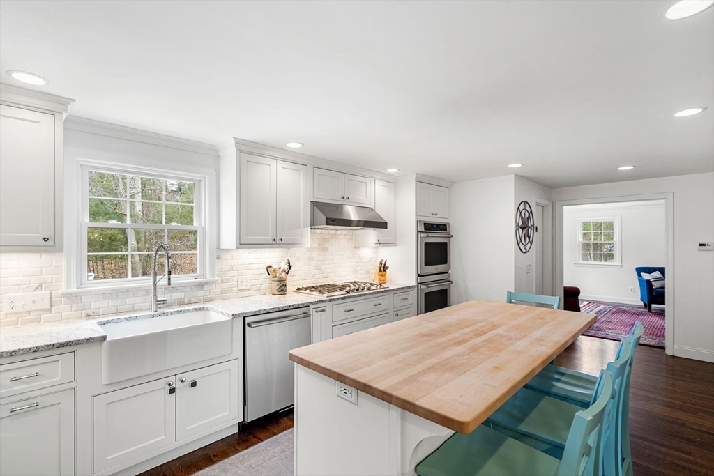 3 Wilmor Road Topsfield, MA 01983 - Photo 6 of 33 a kitchen with a stove a sink a refrigerator and white cabinets with wooden floor