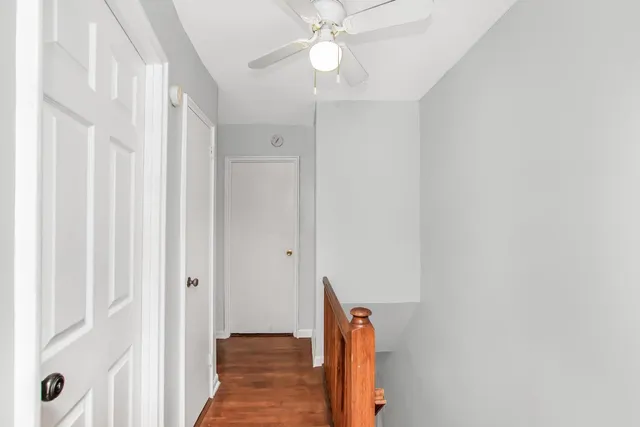 a view of a hallway with a chandelier fan