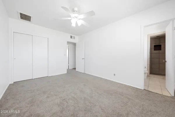 an empty room with a ceiling fan and bathroom