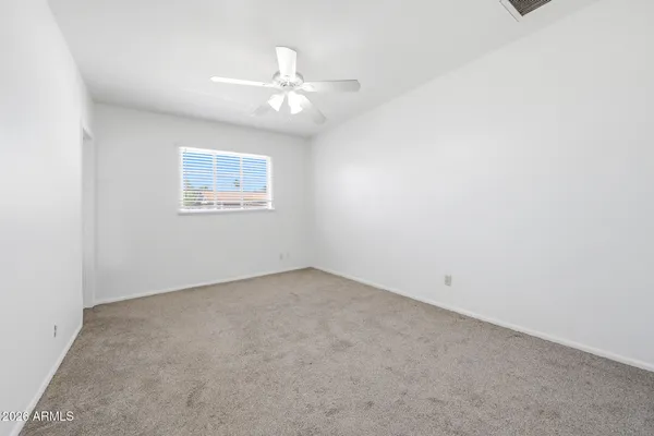 an empty room with a chandelier fan