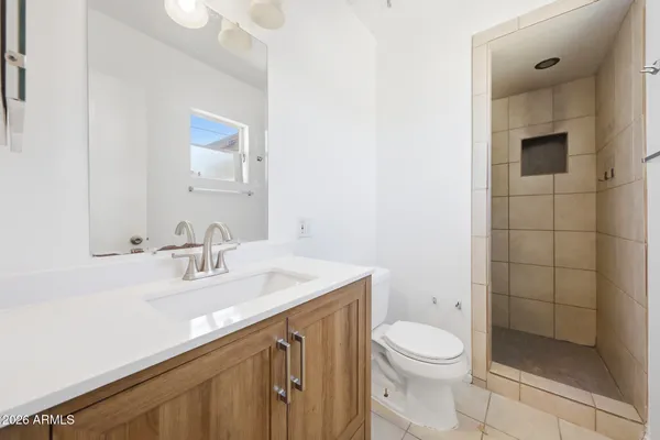 a bathroom with a sink a toilet and shower