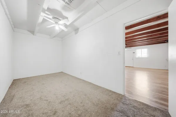 en empty room with windows and ceiling fan