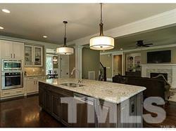 5527 Alpine Drive Raleigh, NC 27609 - Photo 9 of 15 a kitchen with a stove a kitchen island a dining table and chairs
