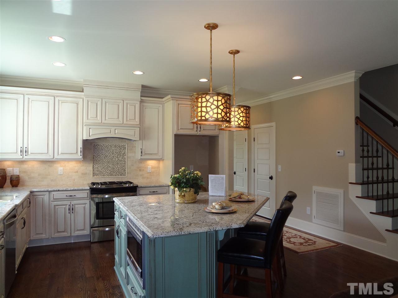 5527 Alpine Drive Raleigh, NC 27609 - Photo 5 of 15 a kitchen with a table chairs and white cabinets