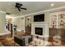 5527 Alpine Drive Raleigh, NC 27609 - Photo 7 of 15 a living room with furniture a flat screen tv and a fireplace