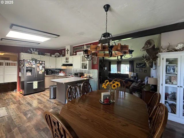 a view of a dining room and livingroom with furniture wooden floor a chandelier