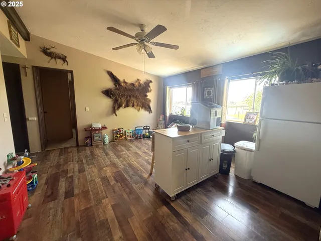 a view of living room with hardwood floor and a ceiling fan