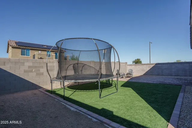 a view of a chair and table in backyard of the house