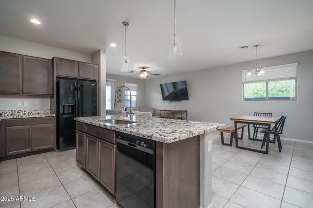 a kitchen with kitchen island granite countertop a sink cabinets and stainless steel appliances