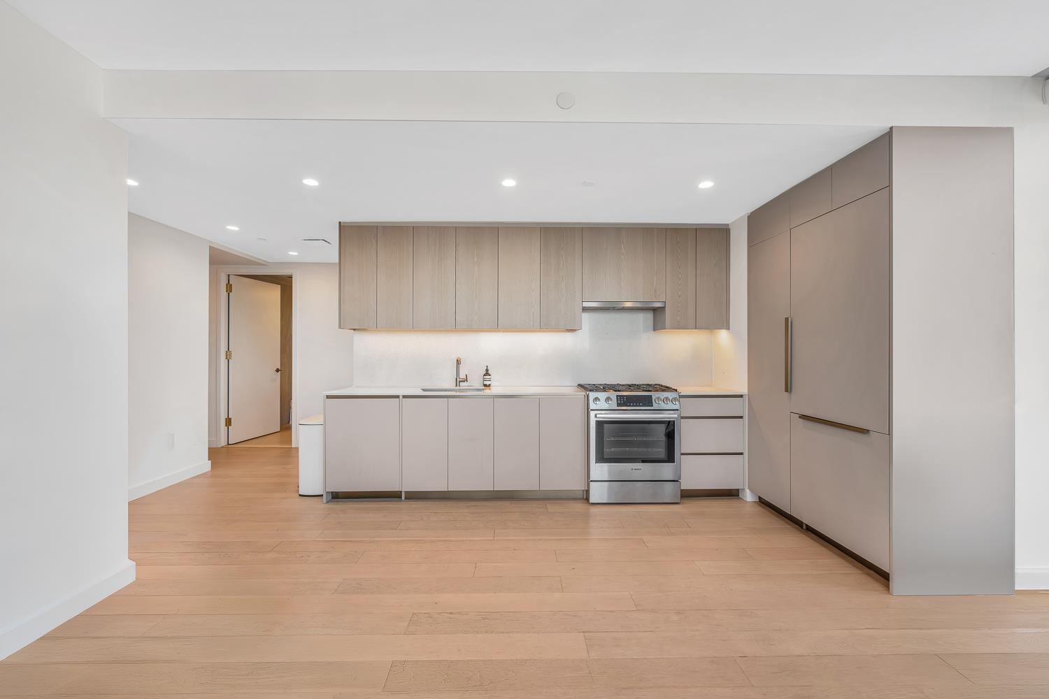 3 Court Square, Unit 902 Queens, NY 11101 - Photo 3 of 11 a large white kitchen with a stove a refrigerator and a sink