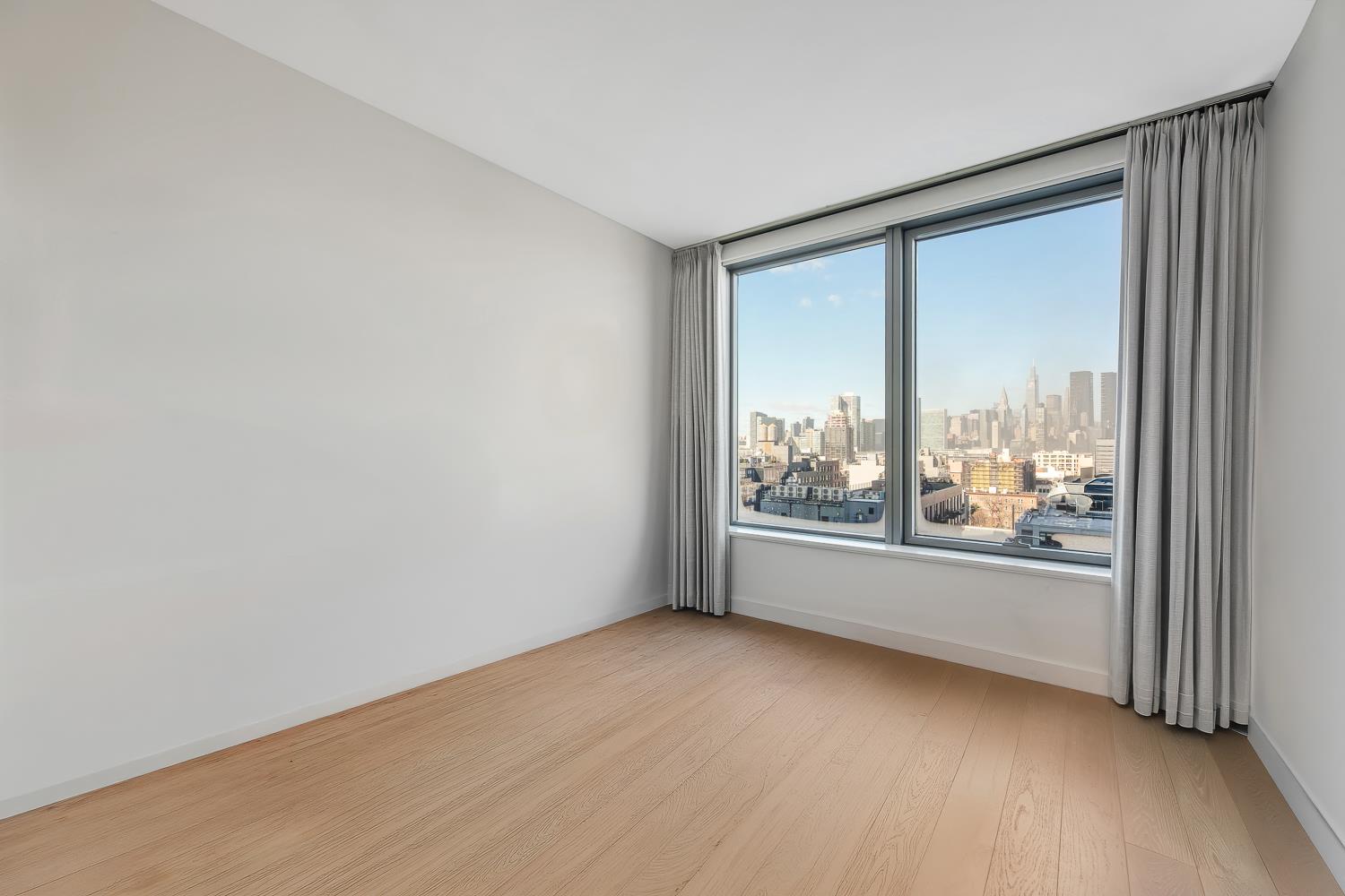 3 Court Square, Unit 902 Queens, NY 11101 - Photo 8 of 11 an empty room with large windows