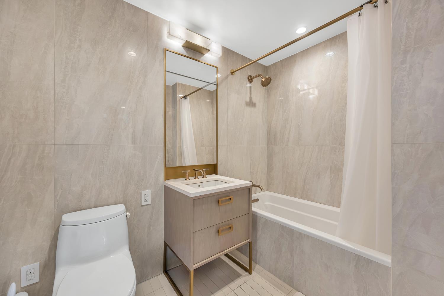 3 Court Square, Unit 902 Queens, NY 11101 - Photo 9 of 11 a bathroom with a sink a toilet and shower