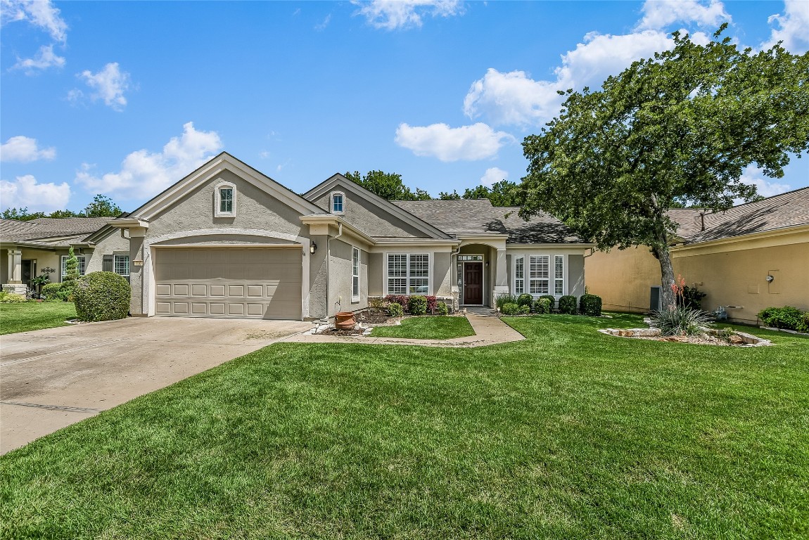 a front view of a house with a garden and yard