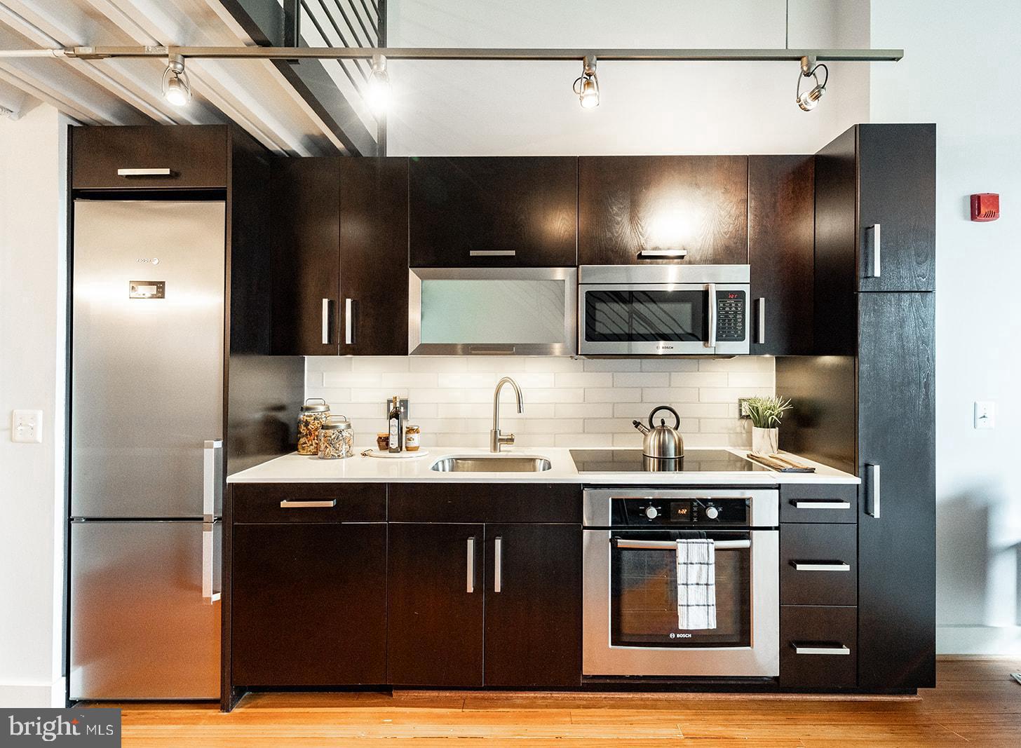 1401 R Street Northwest, Unit 406 Washington, DC 20009 - Photo 5 of 22 a kitchen with stainless steel appliances granite countertop a sink a stove and a refrigerator