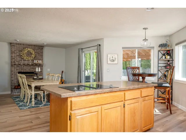 a room with stainless steel appliances kitchen island granite countertop a sink and cabinets