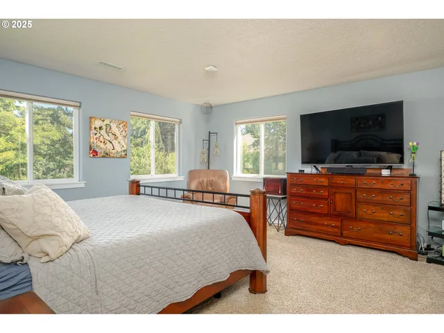 a bedroom with a bed and flat screen tv