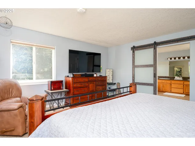 a bedroom with furniture and a flat screen tv