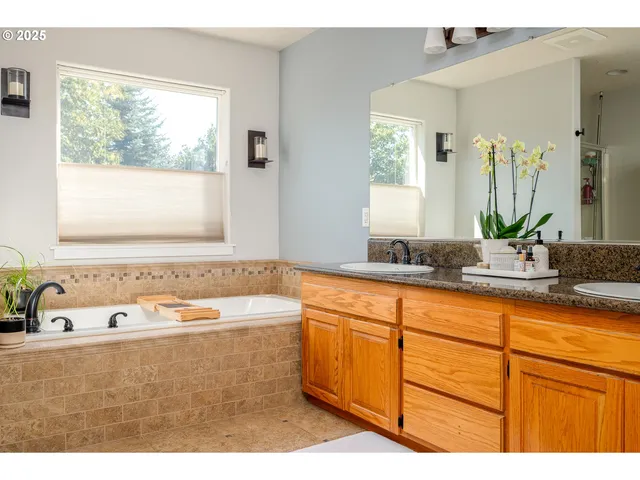 a bathroom with a tub sink and mirror