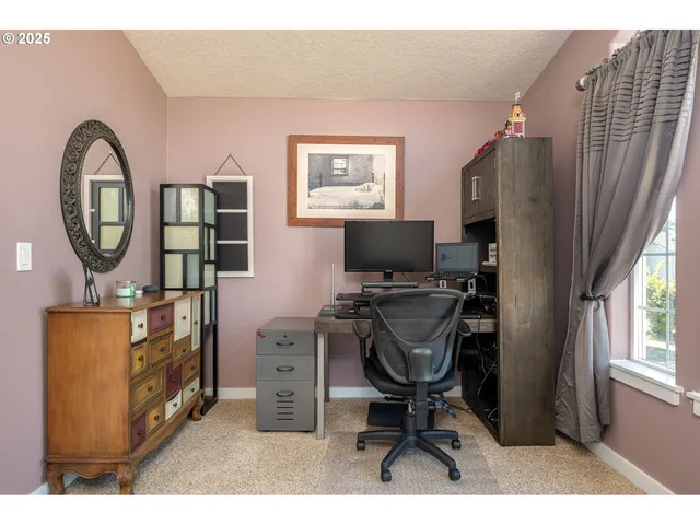 a view of a workspace with furniture and a window
