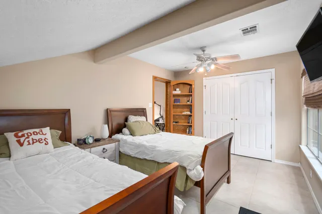 a bedroom with a bed a chair and painting on the wall