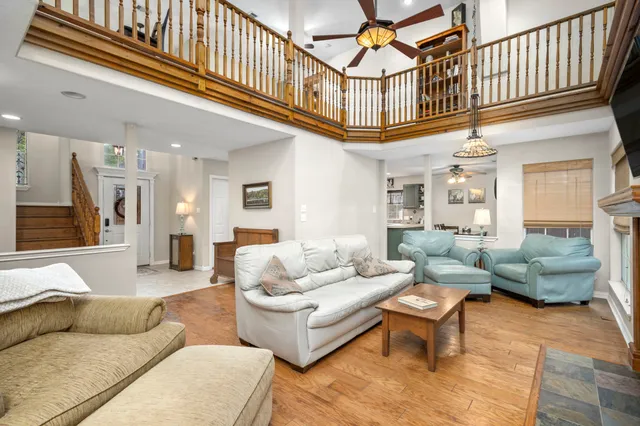 a living room with furniture a rug and a ceiling fan