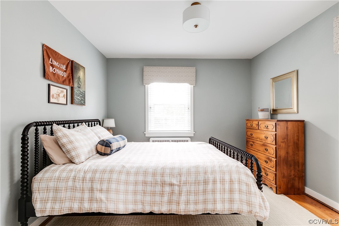 5115 Sylvan Road Richmond, VA 23225 - Photo 28 of 37 a bedroom with a bed and wooden floor