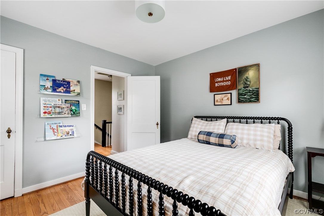 5115 Sylvan Road Richmond, VA 23225 - Photo 29 of 37 a bedroom with a bed and wooden floor