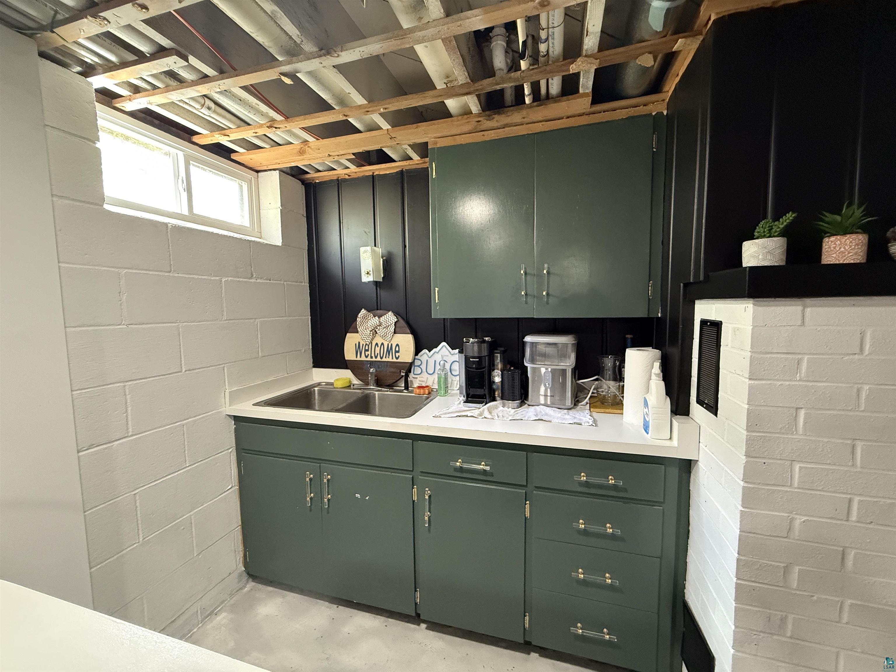 402 Alcohol Road Wrenshall, MN 55797 - Photo 19 of 24 Wet bar area featuring painted cabinetry, a double basin sink, and a white countertop