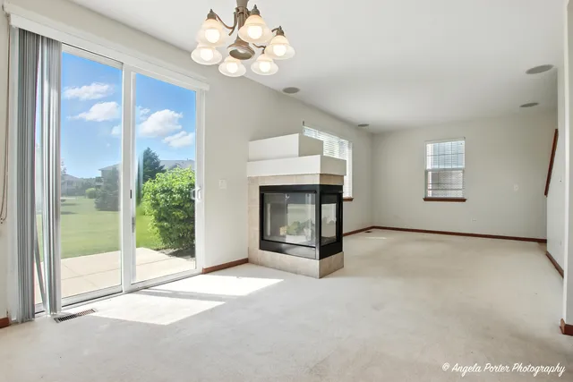 a view of an empty room with a fireplace and a window