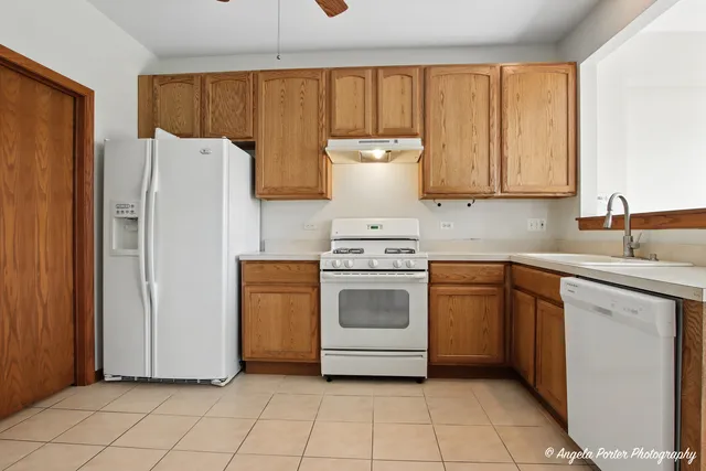 a kitchen with a refrigerator sink and cabinets