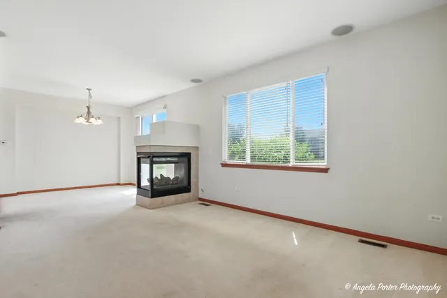 an empty room with a fireplace and window